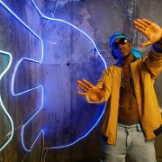 Black rapper in underpass neon light on background